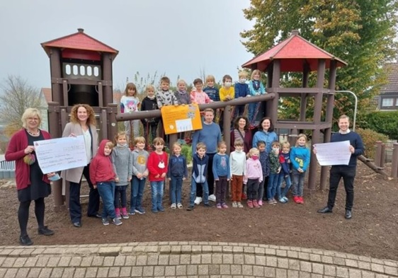 Scheckübergabe Stiftsschule: Kinder und Betreuer an einem Spielgerät.